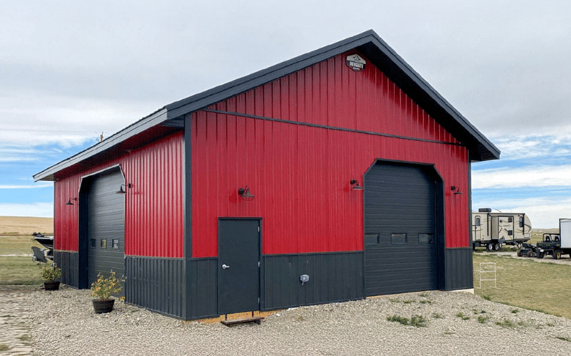 A Dark Red Lifestyle & Hobby post-frame Shop with black Wainscoting and two overhead doors