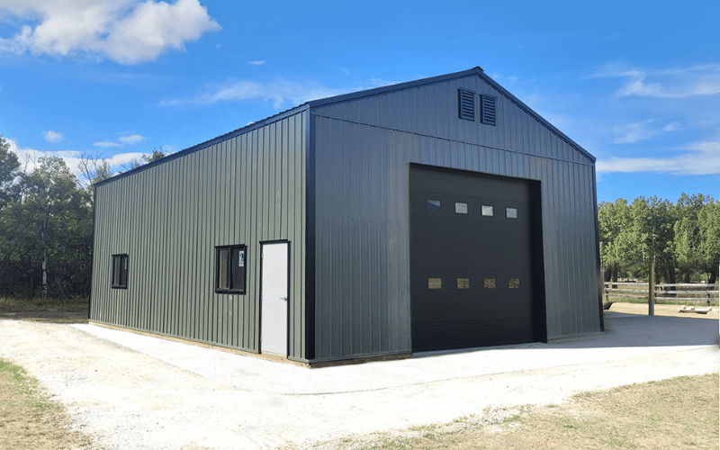 A Dark sage Agricultural post-frame shop with one overhead door