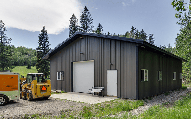 A iron ore Lifestyle & Hobby post-frame shop with soffits and two overhead doors