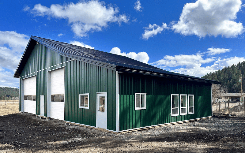 A melchers green lifestyle & Hobby post-frame shop with two overhead doors and soffits