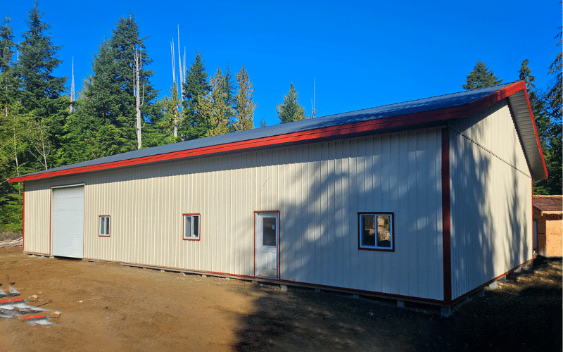 An antique linen agricultural post-frame shop with three overhead doors
