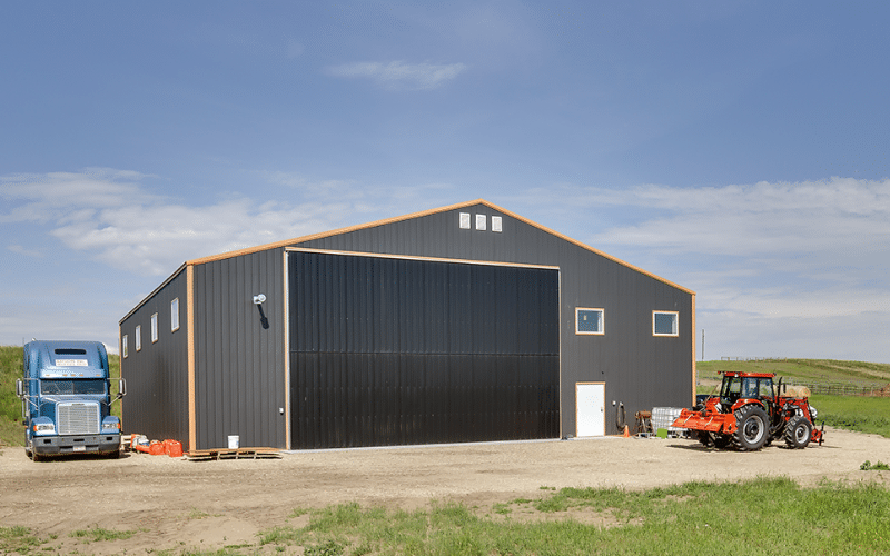 A copper penny agricultural post-frame shop with a bi-fold door