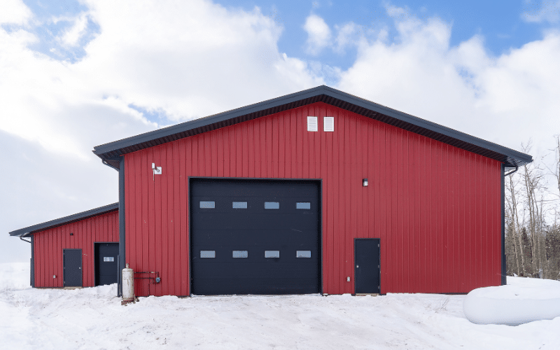 A dark red agricultural post-frame shop with