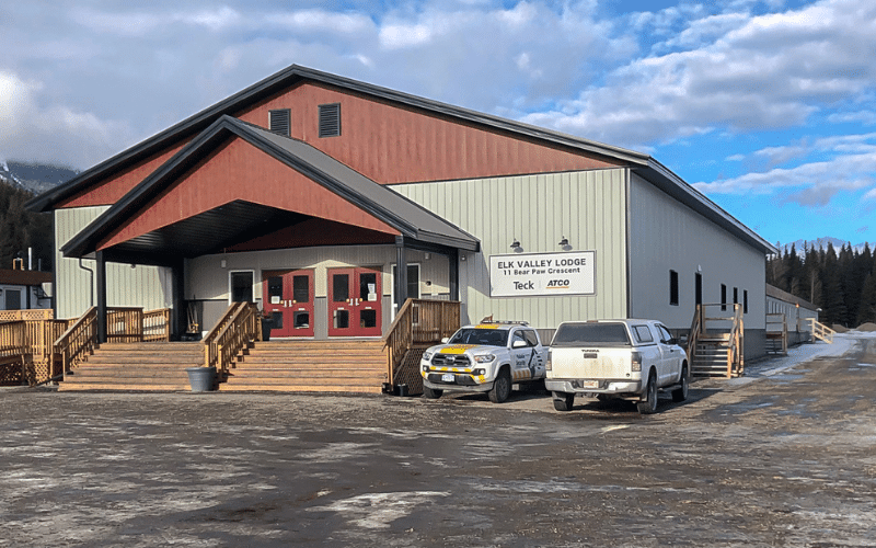 A tan post-frame commercial build with two chain overhead doors