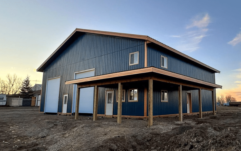 A heron blue post-frame commercial build with four overhead doors