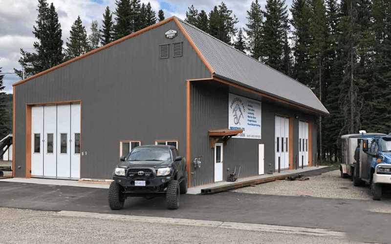 A charcoal post-frame commercial build with three findoors