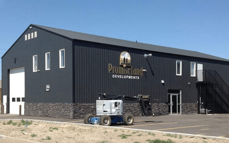 A iron ore post-frame commercial build with wainscoting and three overhead doors