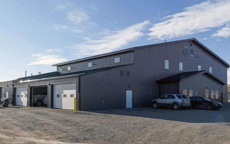 A charcoal post-frame commercial build with five overhead doors