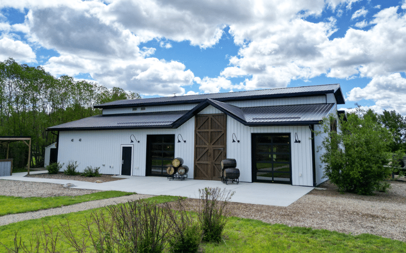 A bright white post-frame commercial build with two overhead doors