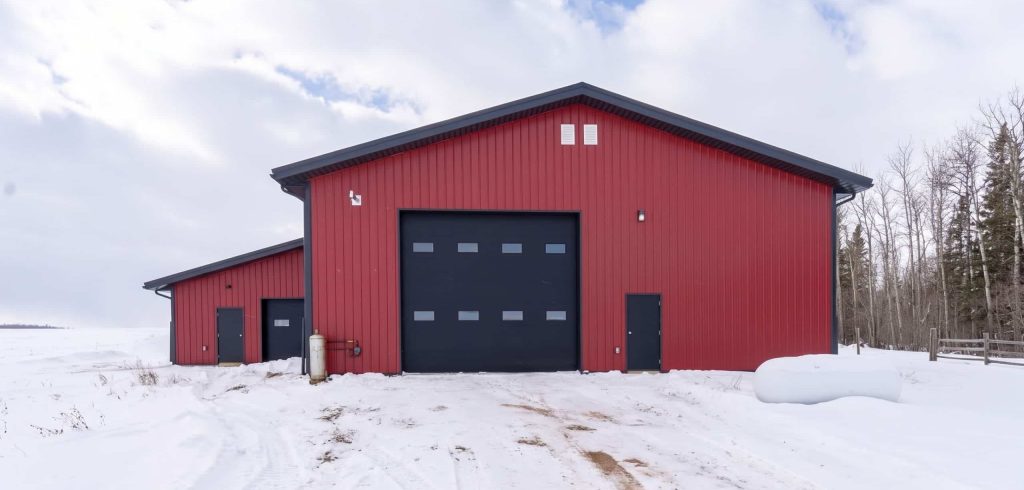 A dark red post-frame agricultural shop