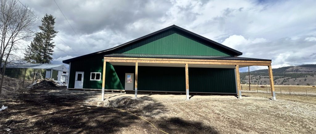 A melchers green lifestyle & Hobby post-frame shop with two overhead doors and soffits