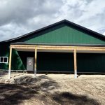 A melchers green lifestyle & Hobby post-frame shop with two overhead doors and soffits
