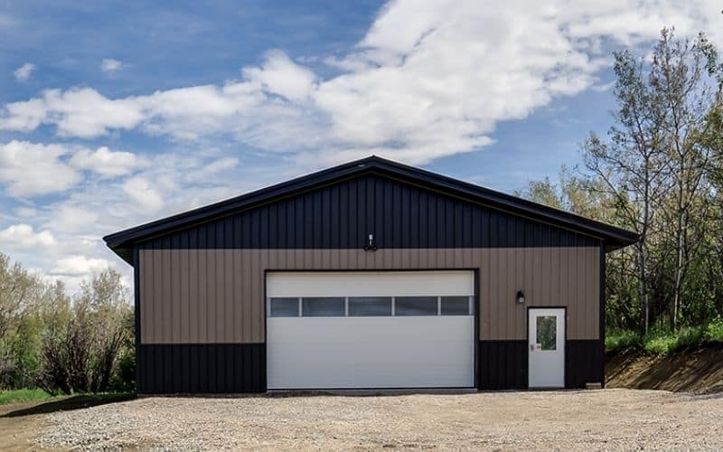 A buckskin lifestyle & Hobby post-frame shop with wainscotting, soffits, and one overhead door