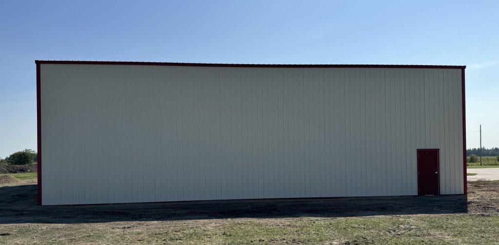 An antique linen post-frame airplane hangar with an overhead and bi-fold door