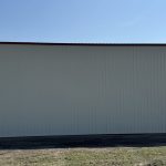 An antique linen post-frame airplane hangar with an overhead and bi-fold door