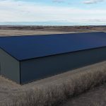 A gunmetal post-frame agricultural storage building with open and closed lean-tos, overhead and bi-fold doors