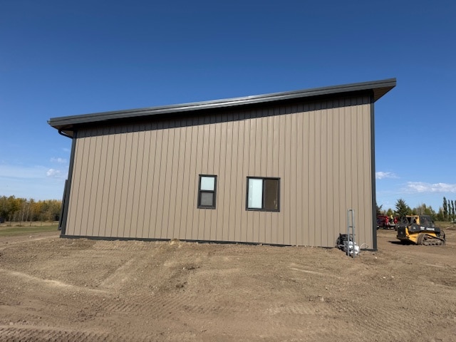 A buckskin post-frame Prairie Peak with soffits, closed lean-tos, and overhead doors