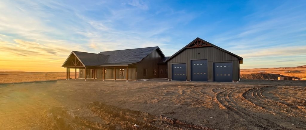 A coffee brown post-frame barndominium with three overhead doors, timber accents, soffits, and open and closed lean-tos
