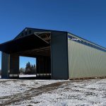 A dark sage post-frame machine shed with sliding doors, overhead doors, and bi-fold doors