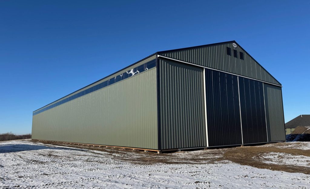 A dark sage post-frame machine shed with sliding doors, overhead doors, and bi-fold doors
