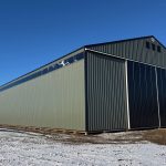 A dark sage post-frame machine shed with sliding doors, overhead doors, and bi-fold doors