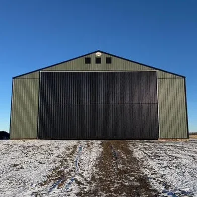 A dark sage post-frame machine shed with sliding doors, overhead doors, and bi-fold doors