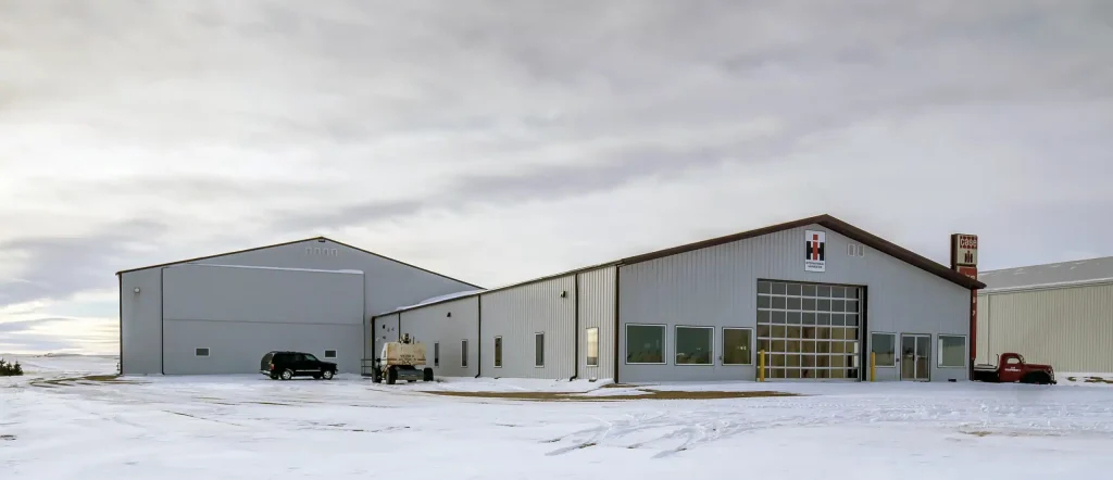 A white white post-frame agricultural machine Shed