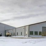 A white white post-frame agricultural machine Shed