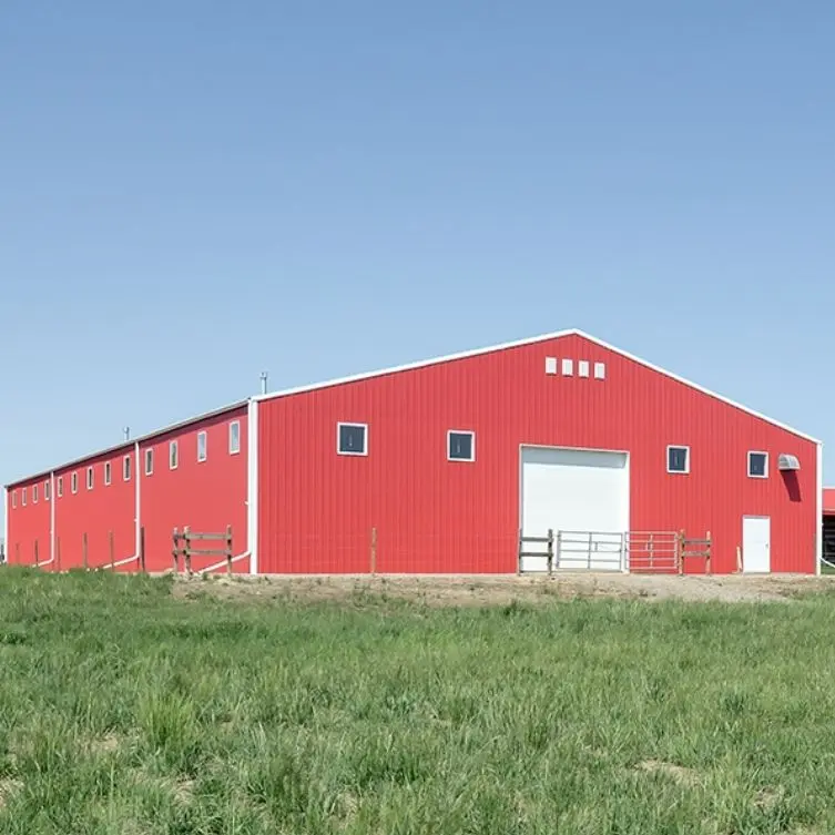 A bright red post-frame riding arena with overhead doors
