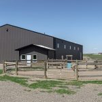 A post-frame riding arena with and overhead door