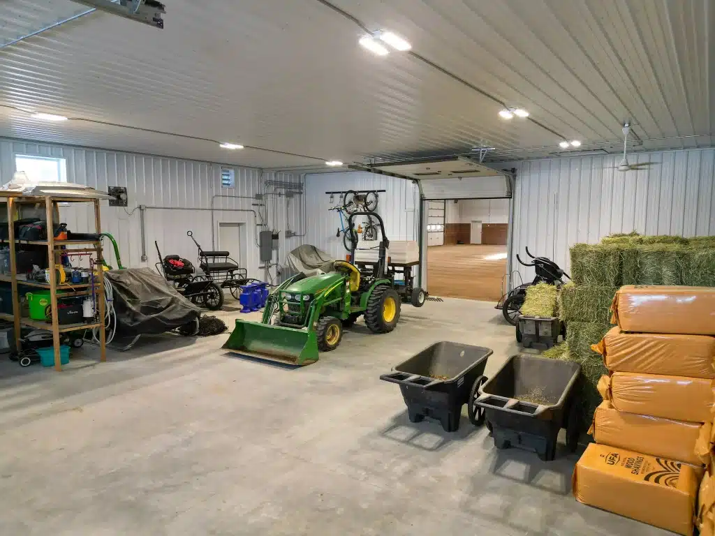 A slate blue post-frame equestrian riding arena