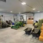 A slate blue post-frame equestrian riding arena