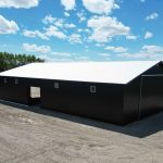 A black post-frame machine shed with a black bi-fold door and two overhead doors
