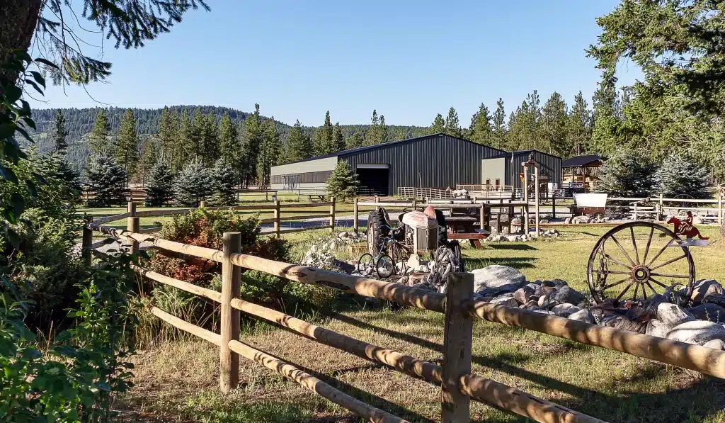 A dark sage post-frame equestrian Riding Arena with overhead doors and skylight