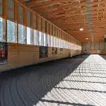 A dark sage post-frame equestrian Riding Arena with overhead doors and skylight