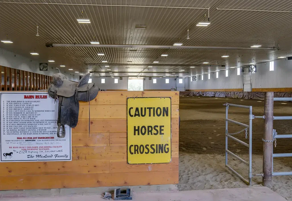 A buckskin post-frame riding arena with two overhead doors
