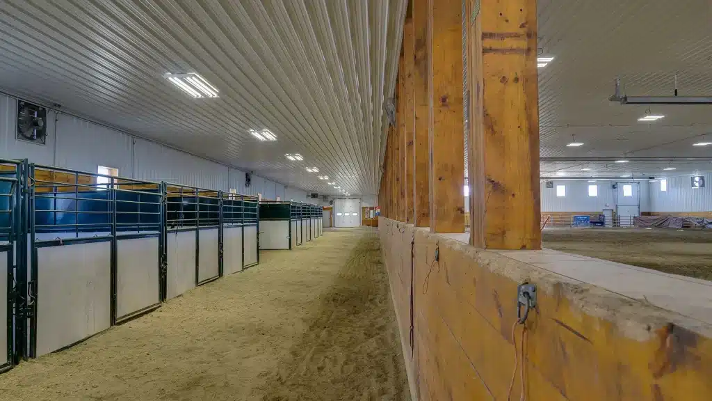 A buckskin post-frame riding arena with two overhead doors