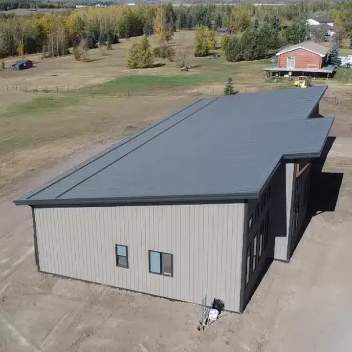 A buckskin post-frame Prairie Peak with soffits, closed lean-tos, and overhead doors