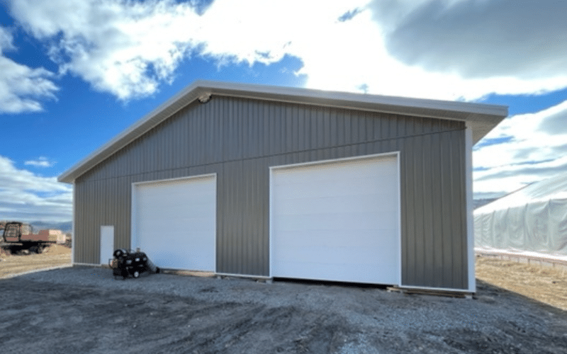A sable post-frame agricultural shop with two overhead doors
