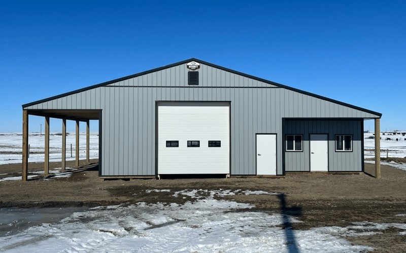 A regent grey post-frame agricultural shop with an overhead door, and open and closed lean-tos