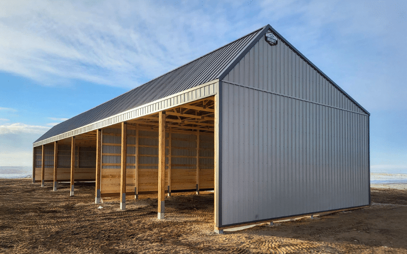 A charcoal open style post-frame Livestock shelter