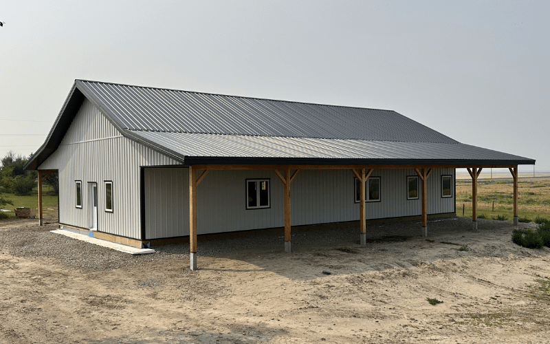 A white white post-frame Ranch Hand with soffits, and open lean-tos