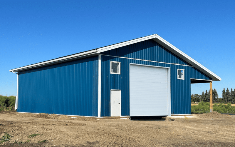 A heron blue post-frame lifestyle & hobby storage building with an open lean-to and soffits