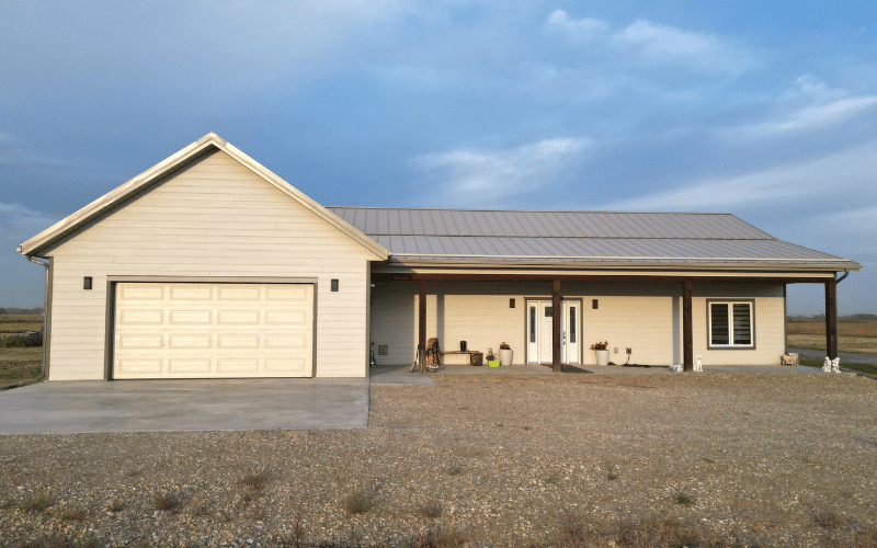 A galvanized post-frame Highwood with Garage, with soffits, overhead door, and open lean-to