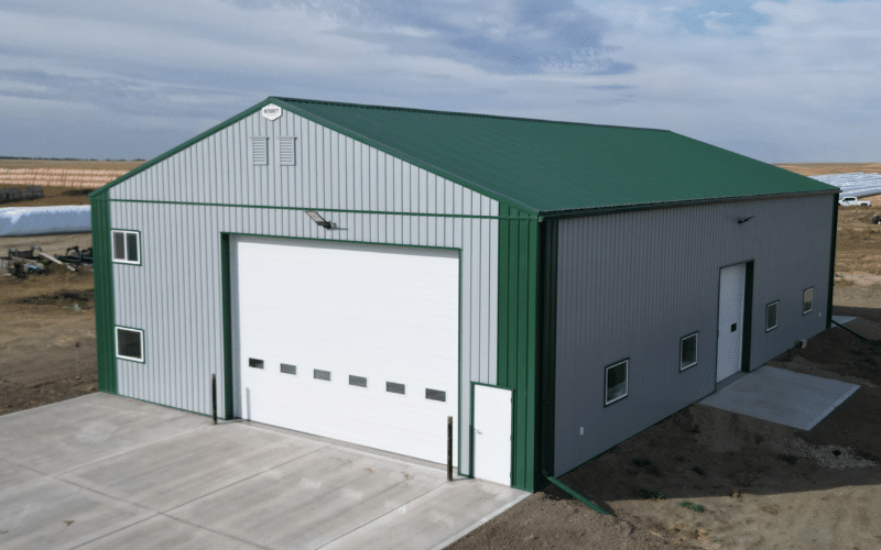 A Regent grey post-frame agricultural shop with melchers green roof and trims