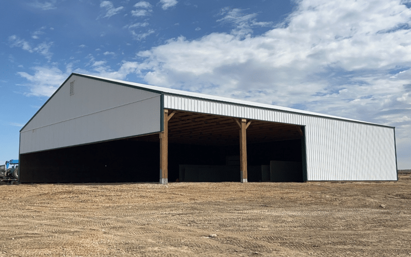 A bright white post-frame equestrian livestock shelter