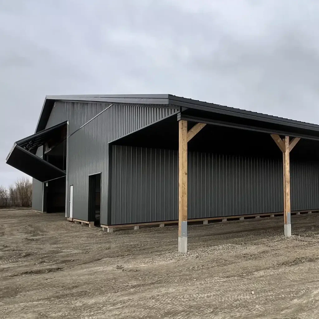 A gunmetal post-frame agricultural storage building with open and closed lean-tos, overhead and bi-fold doors