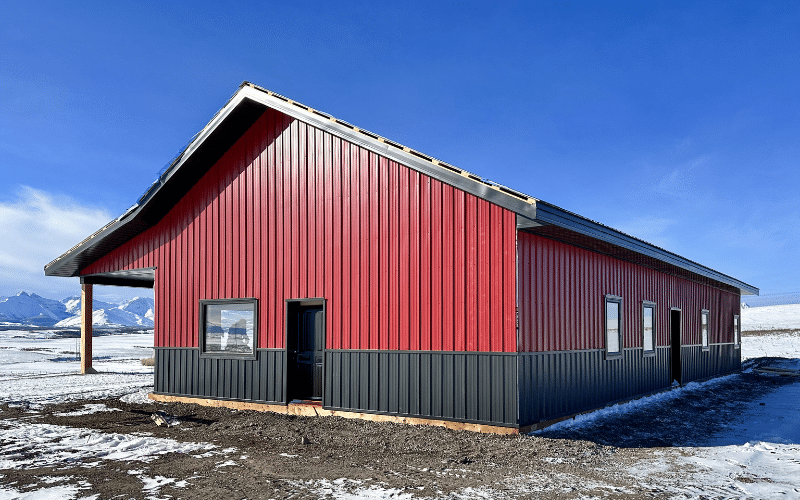 A dark red post-frame Ranch Hand with black wainscoting, and soffits