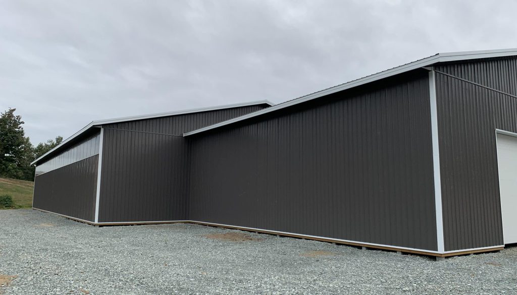 A charcoal post-frame equestrian riding arena