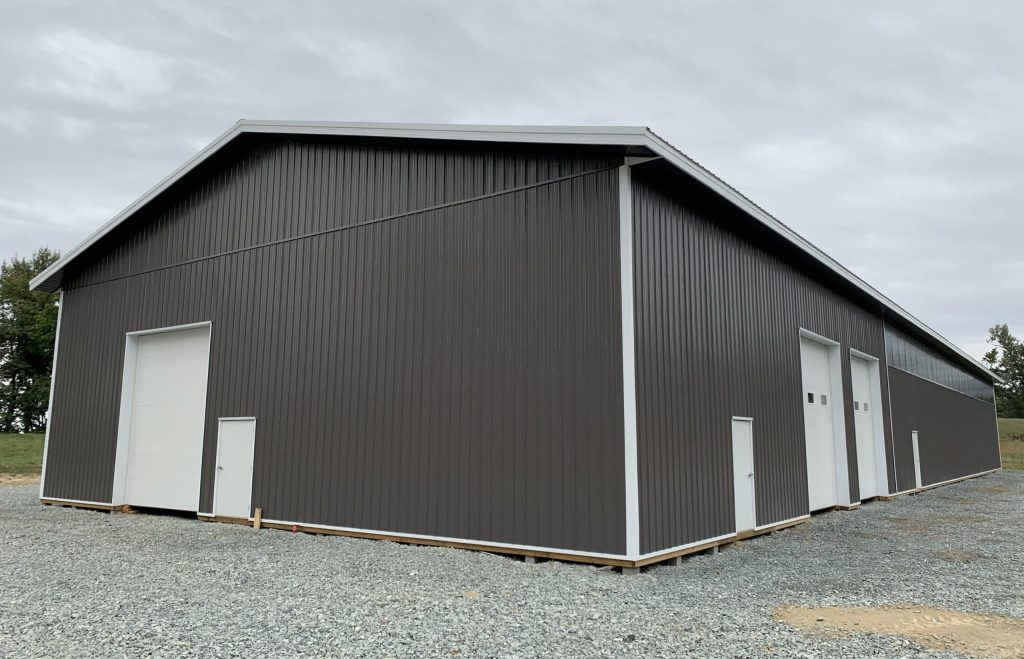 A charcoal post-frame equestrian riding arena